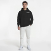 Sweat à capuche noir sans cordon pour homme, modèle "Brief Technique" signé Tourismo Clothing. Hoodie coupe droite avec poche kangourou et capuche structurée. Nouveau placement du logo brodé blanc "TOURISMO ENGINEERED PERFORMANCE" sur la poitrine gauche. Porté par un mannequin debout, de face, main droite en poche, fond blanc studio. Pantalon blanc, sneakers Nike blanches. Look streetwear racé et précis, inspiré de l’univers automobile haut de gamme. Tenue contrastée, élégante, statutaire.