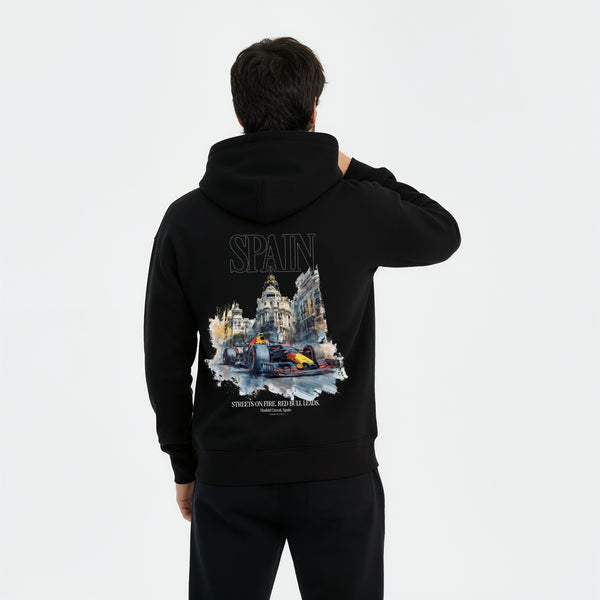 Homme de dos en extérieur portant un hoodie blanc avec grand visuel “SPAIN” et logo Red Bull F1 stylisé