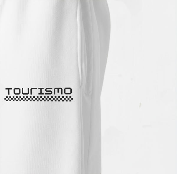 Gros plan sur le logo Tourismo imprimé sur le pantalon de jogging blanc.