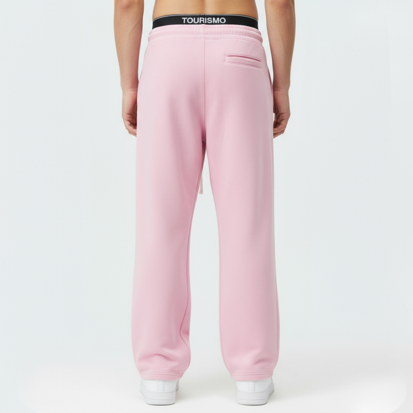 Vue de profil du pantalon de jogging Tourismo Paddock rose, montrant la coupe loose-fit et le tombé sur la chaussure.