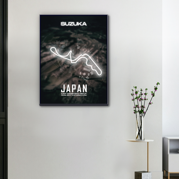 Toile murale circuit F1 Suzuka Japon, tracé néon blanc lumineux sur fond sombre, accrochée dans un intérieur moderne avec plante décorative