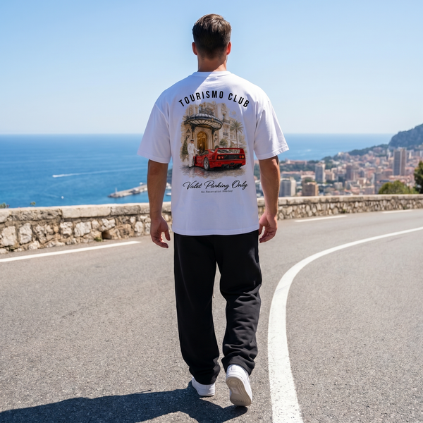 Homme portant le t-shirt blanc Tourismo Club Ferrari F40 sur une route en corniche au-dessus de Monaco