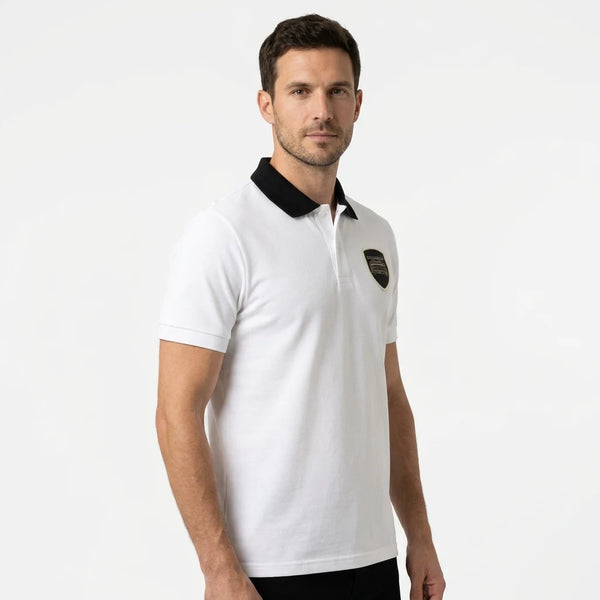Homme portant le polo Porsche GT3 RS blanc col noir, cadré en buste, écusson tissé visible