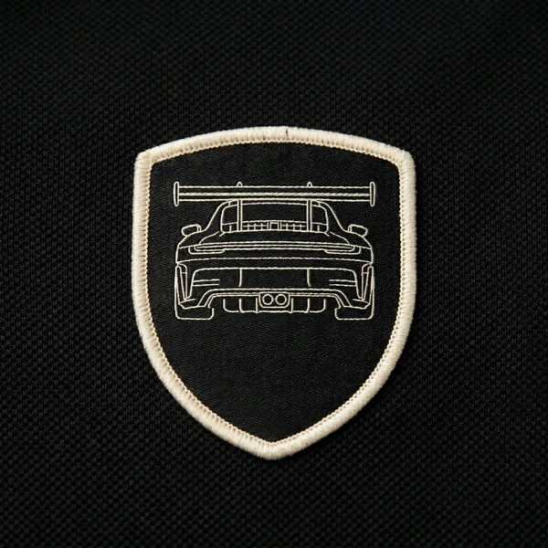 Gros plan sur l'écusson tissé GT3 RS du polo noir
