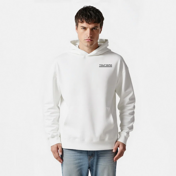 Sweat à capuche blanc minimaliste, logo noir "TOURISMO", homme portant un jean bleu clair, fond blanc.