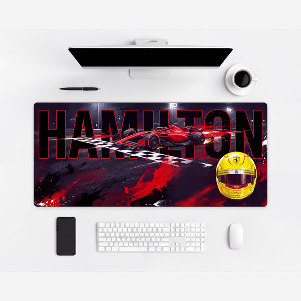 Tapis de souris Lewis Hamilton, première victoire en rouge, mise en situation carrée sur un bureau clair.